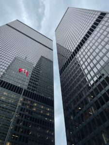 two very tall buildings with a canadian flag on them
